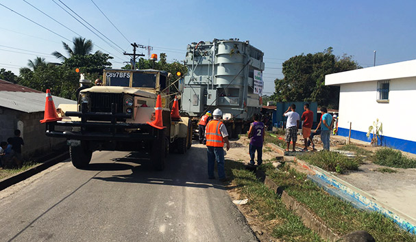 Camión de carga transportando maquinaria pesada en carretera de Guatemala.