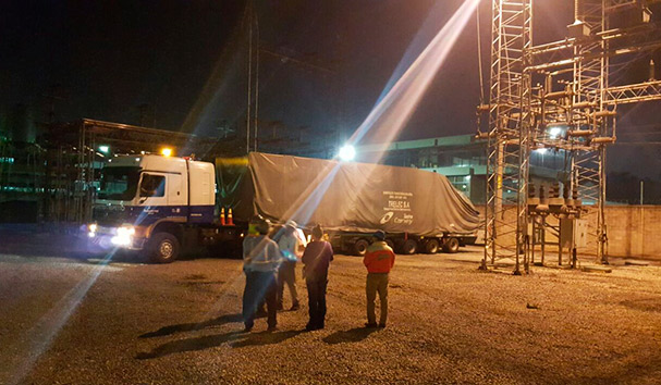 Operador especializado utilizando una carretilla elevadora para mover maquinaria industrial.