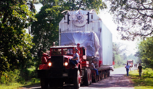 Grúa cargando una máquina en un contenedor para transporte marítimo. Servicios de carga y descarga de Repetto.