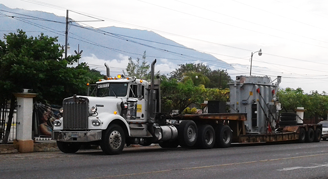 Lowboy transportando equipo industrial en Guatemala, disponible para alquiler